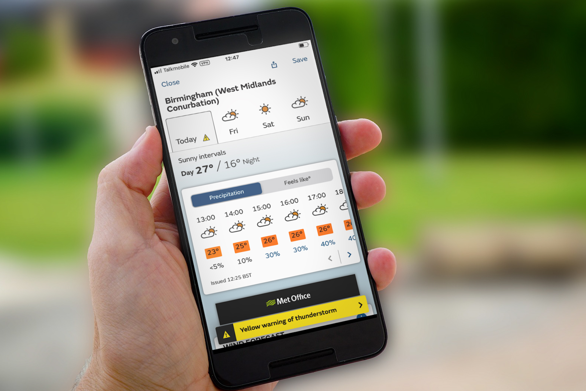 Hand holding a smartphone with the Met Office app showing the forecast for Birmingham.